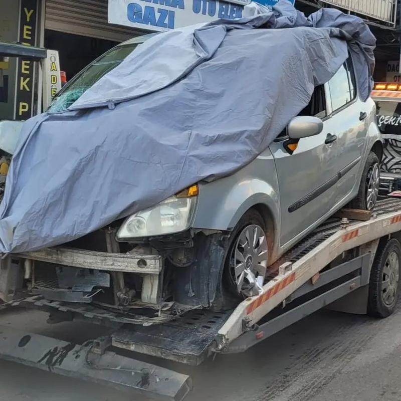 Ağır hasarlı aracın branda ile örtülerek Antalya'da çekici kasasında taşınması